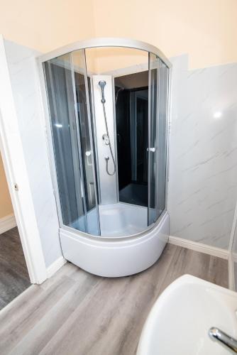 a bathroom with a shower with a large mirror at Converted Historic Hotel in Finley, Sleeps 25 in Finley