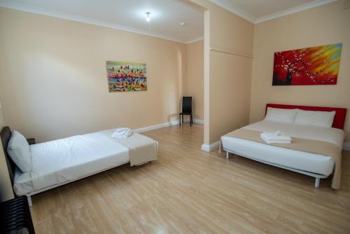 a bedroom with two beds and a painting on the wall at Converted Historic Hotel in Finley, Sleeps 25 in Finley
