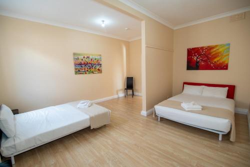 a bedroom with two beds and a painting on the wall at Converted Historic Hotel in Finley, Sleeps 25 in Finley