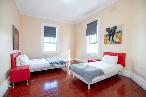 a room with two beds and a bench and windows at Converted Historic Hotel in Finley, Sleeps 25 in Finley