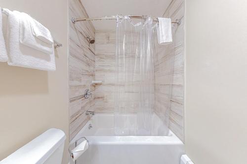 a white bathroom with a tub and a toilet at Alpine Abode in Dover