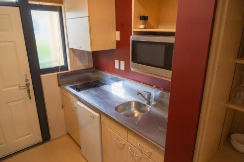 a small kitchen with a sink and a microwave at Victoria Court Motor Lodge - Free Parking in Wellington