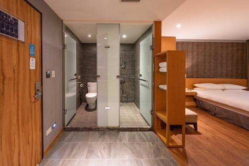 a bedroom with a bed and a bathroom with a shower at 雲富大飯店 Hotel Cloud-ZhongShan in Taipei