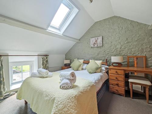 1 dormitorio en el ático con 2 camas y escritorio en Ystabl en Llannon