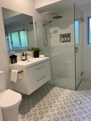 a bathroom with a shower and a toilet and a sink at Selby Cottage in Katoomba