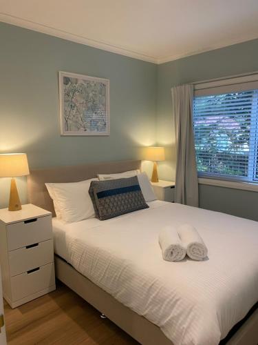 a bedroom with a bed with two towels on it at Selby Cottage in Katoomba