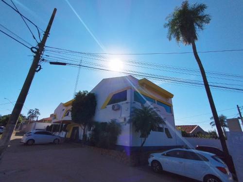 a house with two cars parked in front of it at Hotel Indi Suíte Quádruplo in Ribeirão Preto