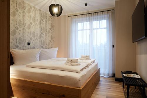 ein Schlafzimmer mit einem Bett mit weißer Bettwäsche und einem Fenster in der Unterkunft Binnendiek Haus 1 Apartment 6 in Büsum