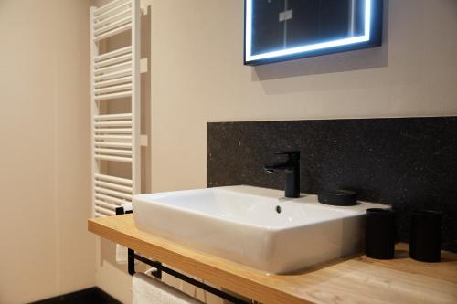 ein Badezimmer mit einem weißen Waschbecken auf einer Holztheke in der Unterkunft Binnendiek Haus 1 Apartment 6 in Büsum