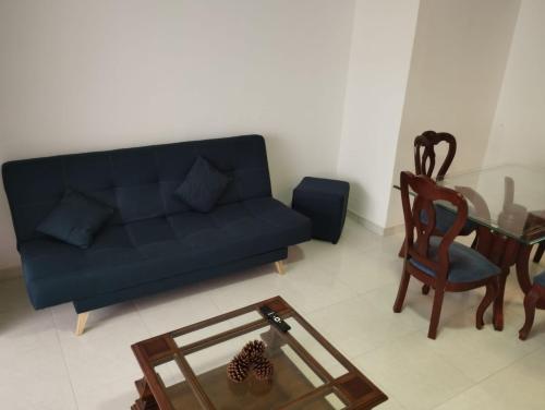 uma sala de estar com um sofá azul e uma mesa em Casa Corferias em Bogotá