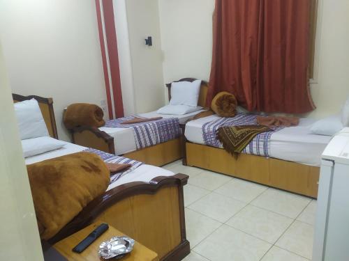 two beds in a room with two dogs sitting on them at Dahab hotel in Suwhaj