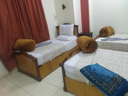 a group of three beds in a room at Dahab hotel in Suwhaj