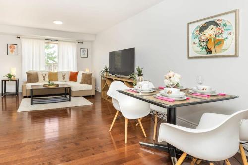 Modern Cozy 4BR Home with Sunny Patio في أوتاوا: غرفة معيشة مع طاولة وكراسي بيضاء