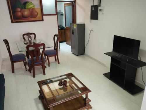 uma sala de estar com uma mesa e cadeiras e uma televisão em Casa Corferias em Bogotá
