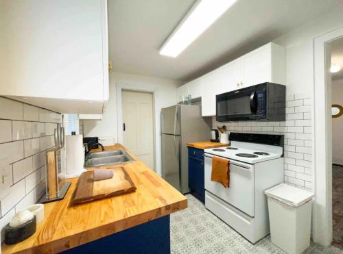 a kitchen with white appliances and a wooden counter top at Two bedroom house in Downtown Asheville in Asheville