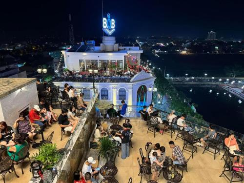 Eine Menschenmenge, die nachts in einem Restaurant sitzt. in der Unterkunft B.O.B Hotel in Cao Lãnh