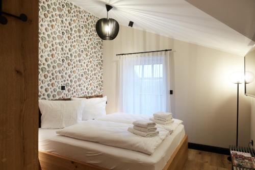 ein Schlafzimmer mit einem weißen Bett mit Handtüchern darauf in der Unterkunft Binnendiek Haus 2 Apartment 11 in Büsum