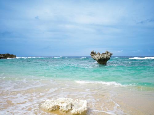 a rock in the water on a beach at Private condo Kourijima by Coldio Smart Resort in Nakijin