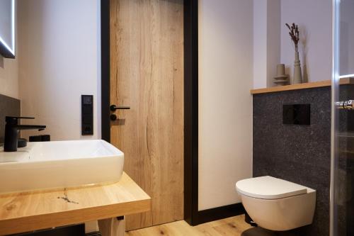 ein Badezimmer mit einem weißen Waschbecken und einer Toilette in der Unterkunft Binnendiek Haus 4 Apartment 1 in Büsum