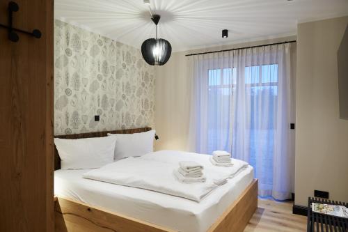 Un dormitorio con una cama con sábanas blancas y una ventana. en Binnendiek Haus 4 Apartment 2, en Büsum