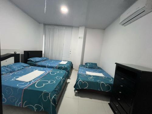 um quarto com duas camas e uma cómoda em Finca Hotel villa el Ocaso Rivera Huila em Riverita