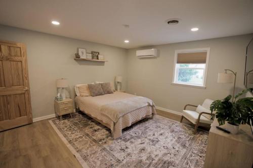 a bedroom with a bed and a chair and a window at The Edamame House in Nazareth