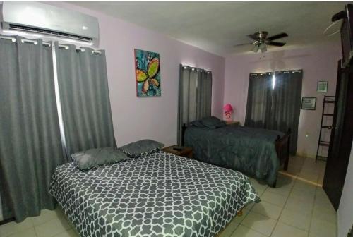 1 dormitorio con 2 camas y ventilador de techo en MyM Departamentos, en Matamoros