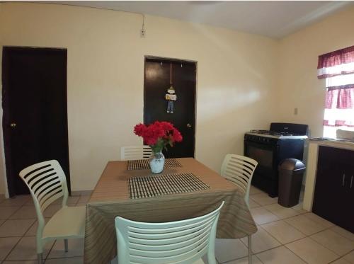 a dining room table with a vase of flowers on it at Departamento Río Nazas in Matamoros