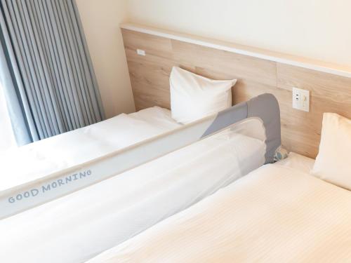 two beds in a small room with a mirror at Private condo Kourijima by Coldio Smart Resort in Nakijin