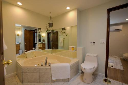 a large bathroom with a tub and a toilet at The Edamame House 