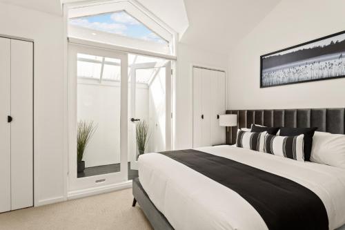 ein Schlafzimmer mit einem großen Bett und einem Fenster in der Unterkunft Central 2-Bed Terrace House by the Harbour in Sydney