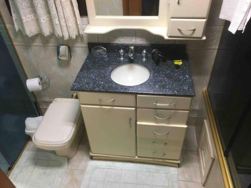 a small bathroom with a sink and a toilet at Casa chácara de lazer altos do pequeno vale in Caxias do Sul