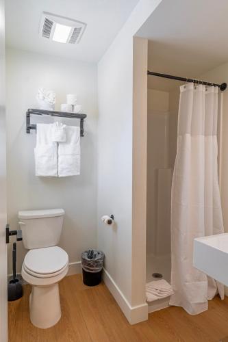 a white bathroom with a toilet and a sink at Casitas at Capitol Reef in Torrey