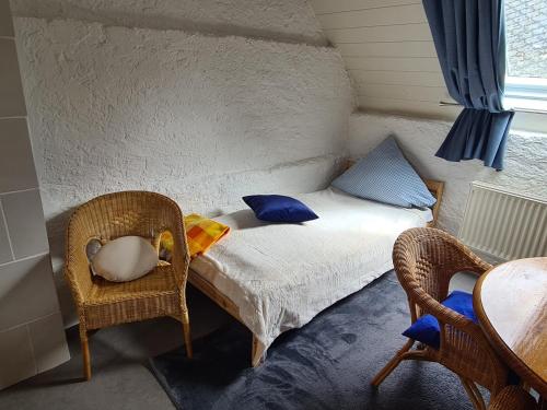 a small room with a bed and two chairs at Ferienhaus am Fährkopf in Zell an der Mosel