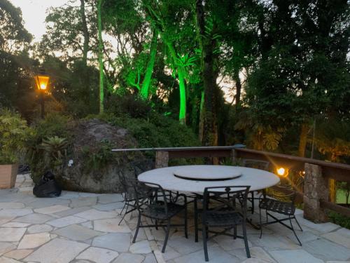 a table and chairs on a patio with green lights at Casa da Pedra Atibaia Clube da Montanha in Atibaia
