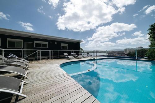 a swimming pool on top of a building with chairs at Mariner Apartments in Port Vila
