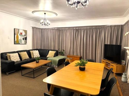a living room with a couch and a table at Tauranga - Stylish & Centrally Located Near Hospital in Tauranga
