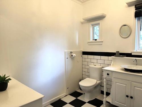 a white bathroom with a toilet and a sink at Tauranga - Stylish & Centrally Located Near Hospital in Tauranga