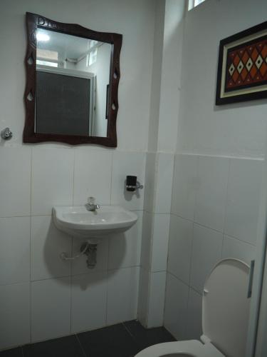 W łazience znajduje się umywalka, lustro i toaleta. w obiekcie ACORI WUHU w mieście Mitú