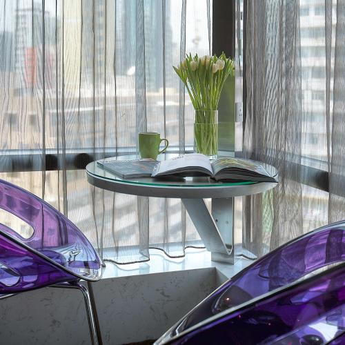 a table with a book and a cup and flowers on it at Stanford Hotel Hong Kong in Hong Kong