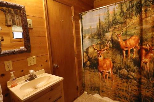 a bathroom with a shower curtain with deer on it at Cozy cabin w/ fireplace 3 minutes to Helen! #2. in Helen