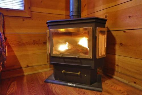 a woodburning stove in a room in a house at Cozy cabin w/ fireplace 3 minutes to Helen! #2. in Helen
