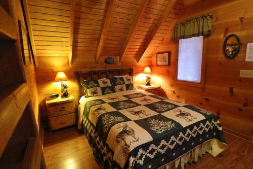 a bedroom with a bed in a log cabin at Cozy cabin w/ fireplace 3 minutes to Helen! #2. in Helen