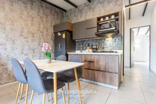 a kitchen with a table and some blue chairs at Nuevo Apartamento a 2 minutos del JMC jacuzzi in Rionegro