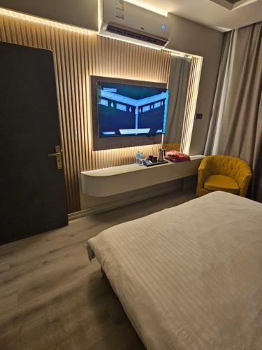 a hotel room with a bed and a flat screen tv at Yasmine in Dammam