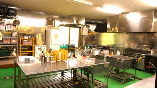 een grote keuken met roestvrijstalen werkbladen in een keuken bij LivingAnywhere Commons Aizu Bandai Mixed Dormitory - Vacation STAY 14957v in Inawashiro