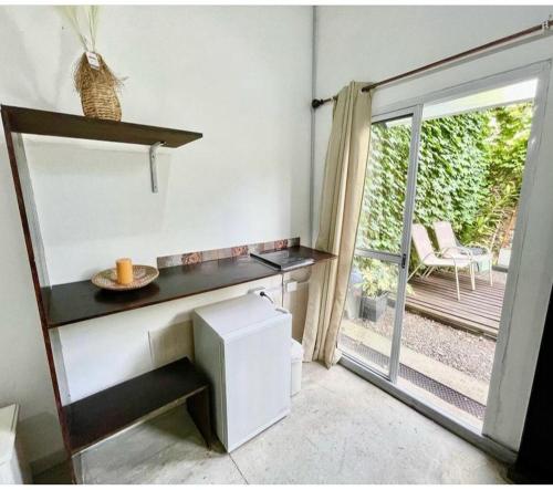 eine Küche mit einem Schreibtisch und einer Glasschiebetür in der Unterkunft Arguibel 2833 in Buenos Aires