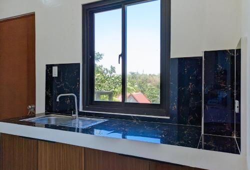 a bathroom with a sink and a window at RedDoorz @ LM Apartelle Boracay in Boracay