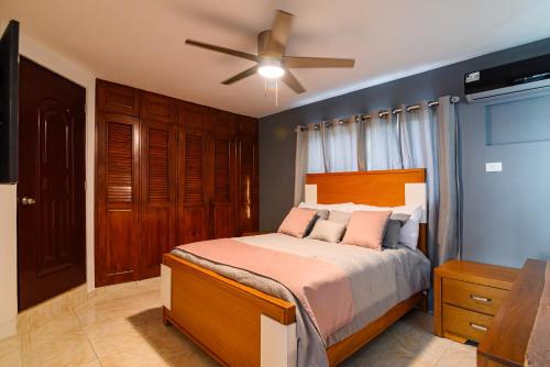a bedroom with a bed with a ceiling fan at Villa Lugo Lahoz in San Felipe de Puerto Plata