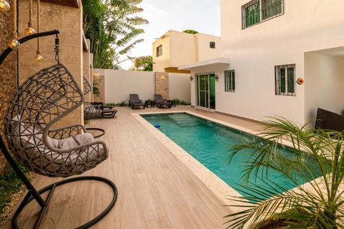 a house with a swimming pool with a swing at Villa Lugo Lahoz in San Felipe de Puerto Plata